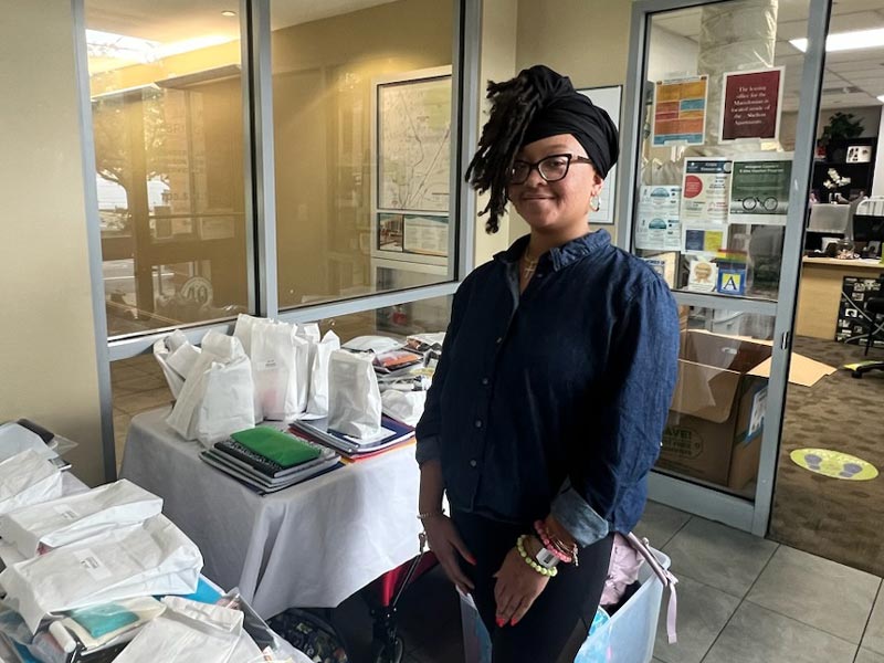 Ms. CeSha Whitfield, the Bridges to Independence Youth Development Manager, distributing school supplies to families within the community.
