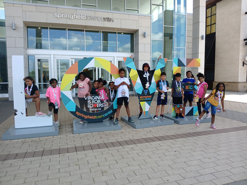 Children standing with Virginia is for Lovers sign at Bridges' 1st. Summer camp for local youth