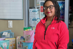 Youth Development Manager CeSha Whitfield distributing books and STEM projects to support community youth in reading and learning.