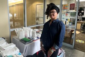 Ms. CeSha Whitfield, the Bridges to Independence Youth Development Manager, distributing school supplies to families within the community.