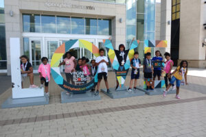 Children standing with Virginia is for Lovers sign at Bridges' 1st. Summer camp for local youth